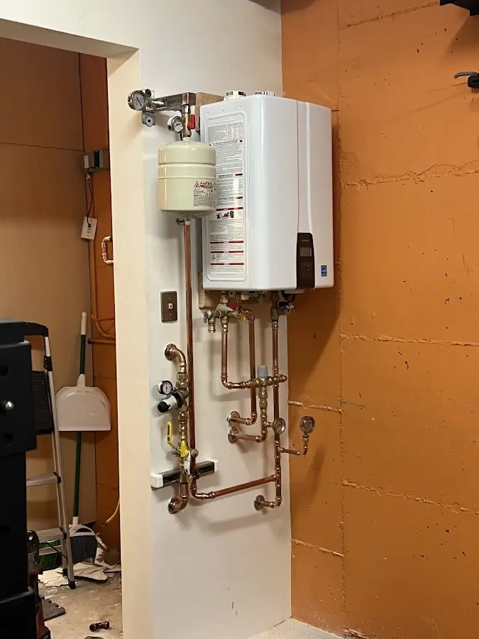 Plumbing technician inspecting water heater connections in Kendale Lakes